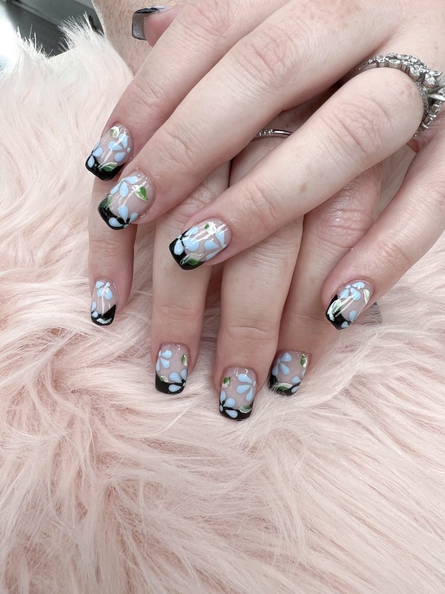 Black French tips with hand-painted blue flowers at Tip N’ Toe